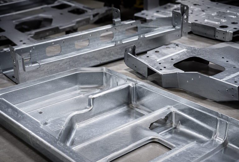 Galvanised steel EV battery tray sections and chassis brackets with hemmed edges